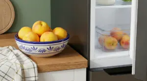 Pesche conservate in una ciotola sul piano cucina e in un contenitore dentro il frigorifero