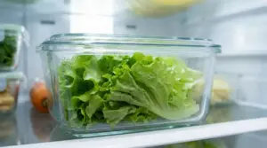 Lattuga fresca conservata in un contenitore di vetro dentro un frigorifero