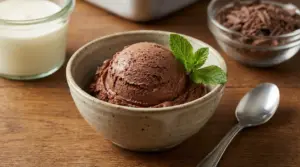 Coppa di gelato al cioccolato fatta in casa, decorata con foglie di menta